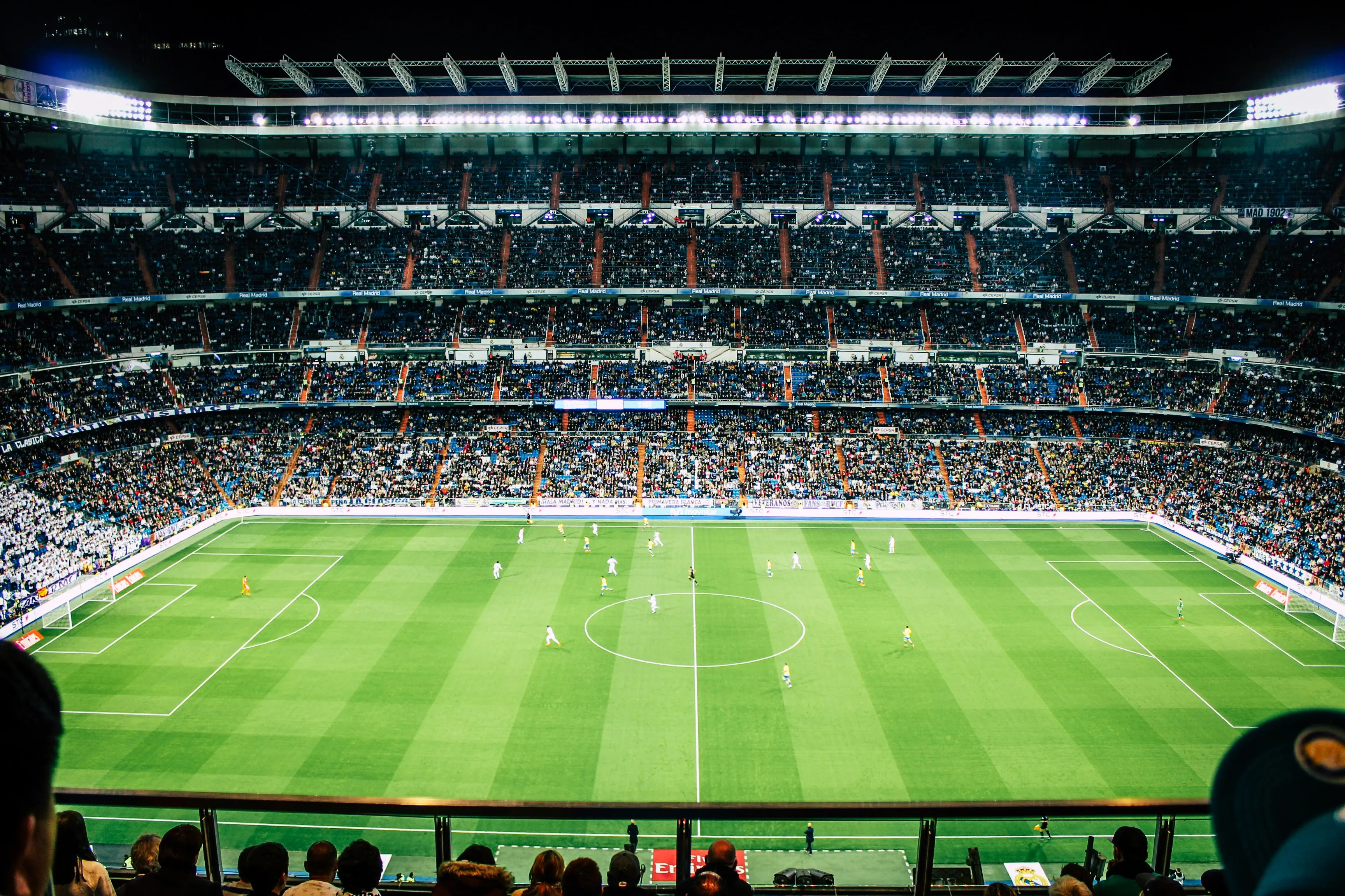 A packed football stadium at night during a match.